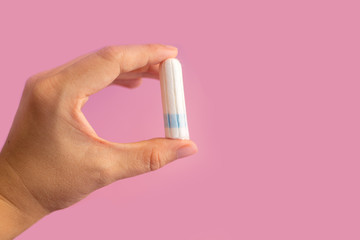 Menstrual tampon  on a pink background. Menstruation time. Hygiene and protection. Pasterl colors.
