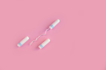 Menstrual tampon  on a pink background. Menstruation time. Hygiene and protection. Pasterl colors.
