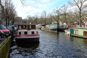 Fototapeta na wymiar Traditional old buildings and and boats in Amsterdam, . Canals of Amsterdam