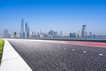 empty asphalt road with city skyline