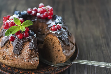 Homemade chocolate cake with chocolate icing, mint  and fresh berries.