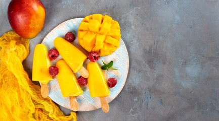 Mango sorbet on round blue tray popsicles seeing from above