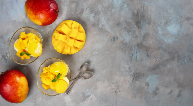 Mango sorbet in two glass cups on concrete background