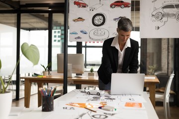 Businesswoman using laptop in office