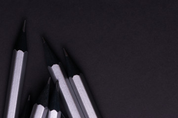 Gray sharpened pencils close-up on a dark background.