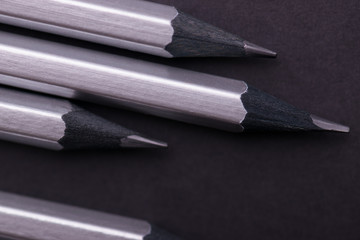 Gray sharpened pencils close-up on a dark background.