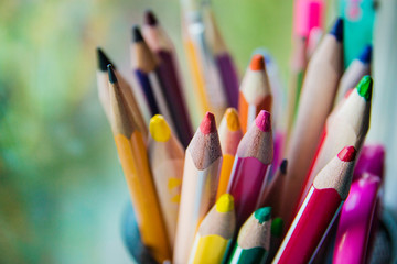 various colored pencils in the glass, selective focus
