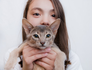 a girl with her pet kitten on her hands posing for the camera