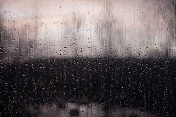 drops of rain on a windowpane on a sunset background