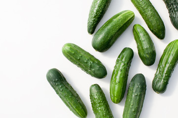 Many young cucumbers on a white background