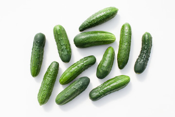 Many young cucumbers on a white background