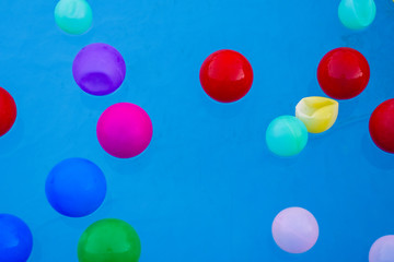 colored balls floating in a pool