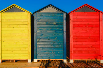 Cabins changers for bathers on a beach of the Mediterranean in summer, colored blue, yellow and red.