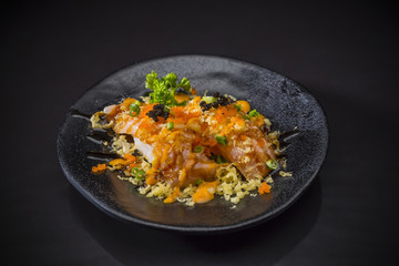 Aburi Spicy Salmon Nigiri, Burned Salmon Sushi and topped with Shrimp Eggs, tempura and spicy sauce served on traditional Japanese food on ceramic dish, Japanese food style,  selective focus