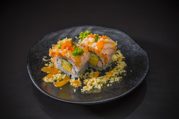Salmon Sushi-Roll with  sauce and Tempura, Japanese food on ceramic dish, Japanese food style, Sushi Menu, salmon sushi roll on black background, selective focus