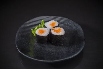 Ebiko served on traditional Japanese food on ceramic dish, Japanese food style, Sushi Menu, shrimp eggs sushi maki roll on black background, selective focus