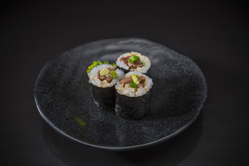 Wagyu Maki Roll served on traditional Japanese food on ceramic dish, Japanese food style, Sushi Menu, Wagyu sushi maki roll on black background, selective focus
