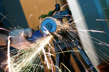 Angle grinder in use, cutting pipes for waterwork.