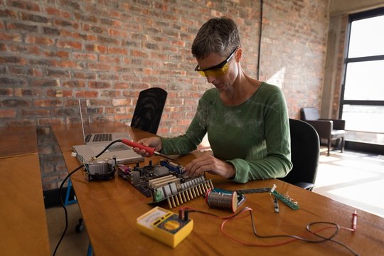 Female electrical engineer soldering a circuit board