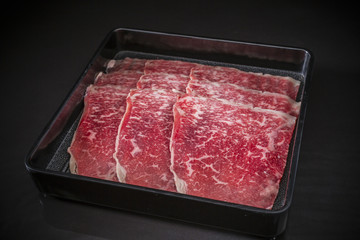 Thin sliced beef for Shabu Shabu, Sliced Wagyu Beef, shabu shabu, sukiyaki, raw food on black background