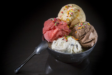 Ice cream scoops in bowl, Mixed ice cream in ice cream cup on black background
