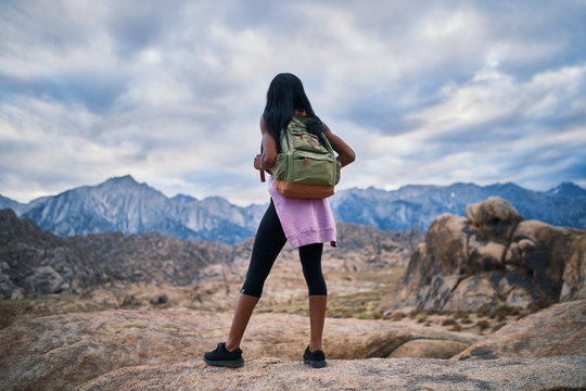 african american woman stopping to look at impressive view during hike at alabama hills park california