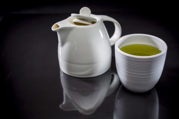 Green tea and teapot, Organic Green Matcha Tea, Cup with green tea on black background, drink for health, Hot green tea, copy space