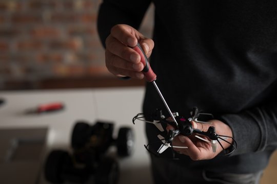Male electrical engineer repairing a drone