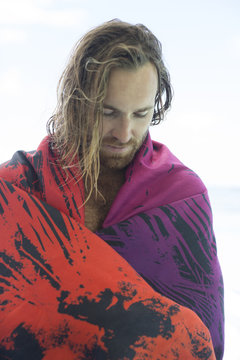 Man on beach in blanket