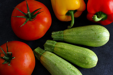 Variety of fresh vegetables on dark board, top view