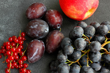 Choice of summer fruit on dark board, top view, close up