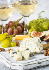 Cheese plate with grapes, figs and nuts.
