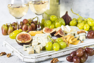 Cheese plate with grapes, figs and nuts.