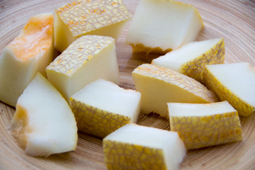 Slices of ripe melon on wooden table close up

