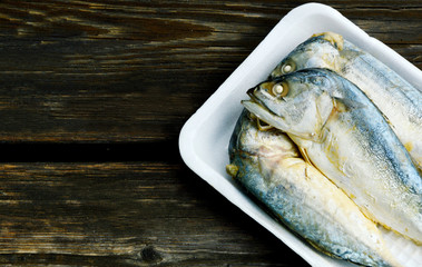 Mackerel steamed  on foam tray with wooden background.