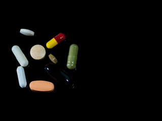 Pile of pills on black background.