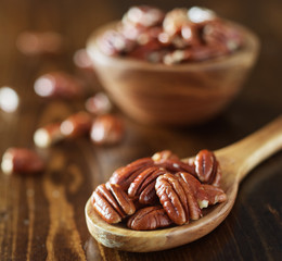 pile of pecans on wooden table shot close up