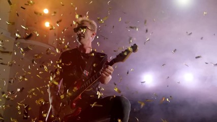 Concert rock band performing on stage with singer guitar. Music video punk, heavy metal or rock group. The guitarist performs on stage. Stage light, smoke. Male playing electric guitar - Powered by Adobe