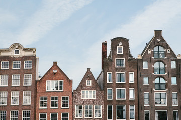 Fototapeta na wymiar Traditional houses in Amsterdam in the Netherlands in a row against the blue sky.