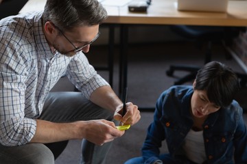 Male executive writing on sticky notes during discussion