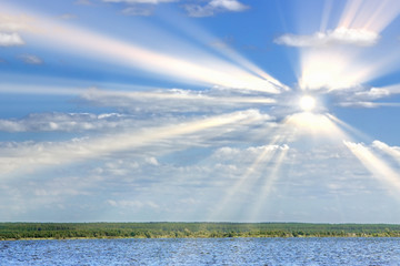 beautiful summer landscape with white clouds in the blue sky in the rays of the sun