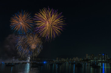 night fireworks over the ocean with floating yachts and ships