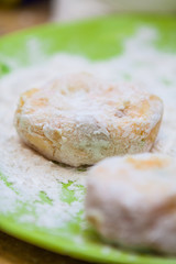 Fototapeta na wymiar Closeup of Raw Fish and Sweet Potato Cakes (Latkes) in Flour on a Plate