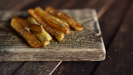 French fries with spices on wooden table

