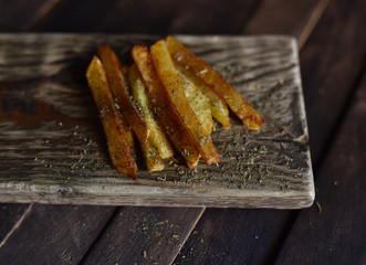French fries with spices on wooden table

