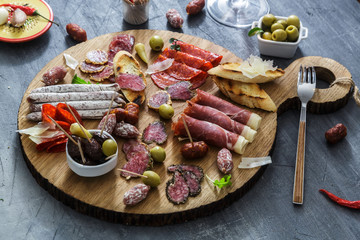 Typical spanish tapas concept. include variety slices jamon, chorizo, salami, bowls with olives, peppers. Copyspace.
