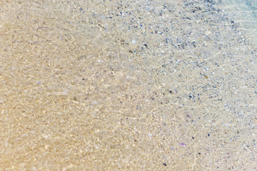 Water texture. Close-up of beach, with sun reflection, soft waves, foamed, turquoise waters and fine yellow sand on the Black Sea coast. Concept summer. Negative space.