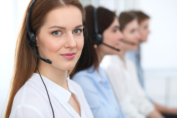 Call center. Beautiful cheerful smiling operator consulting clients with headset. Business concept...