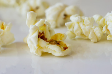 Close-up of a delicious popcorn texture on a white bacground. Shallow dept of field. Concept food by nature.