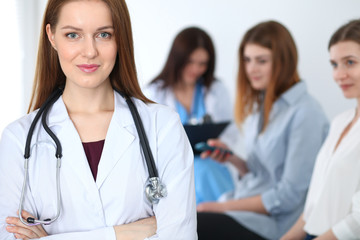 Young beautiful female doctor smiling while consulting her patient. Physician at work. Medicine and healthcare concept